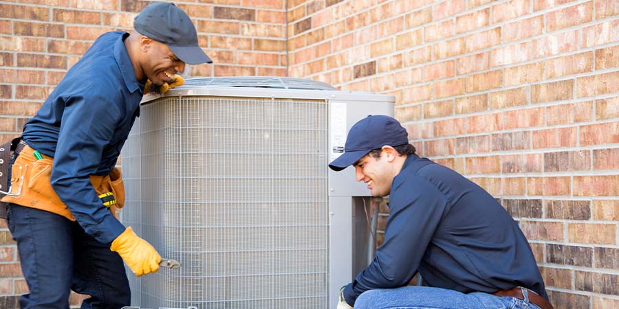 Technicians installing new air conditioner